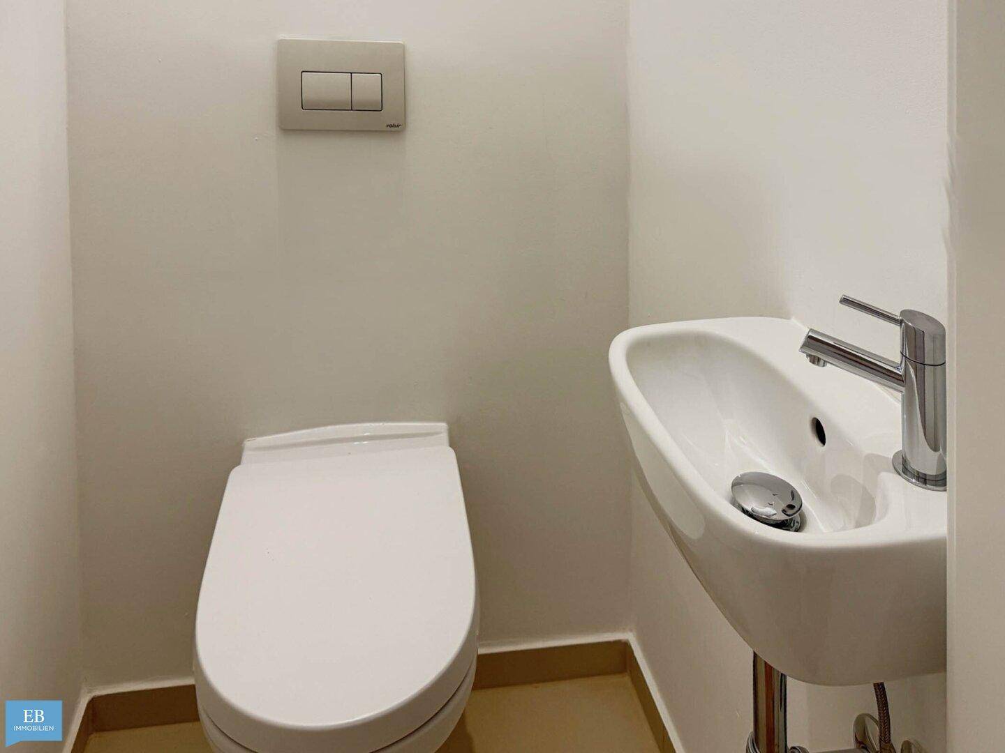 Kleines Gäste-WC mit wandhängender Toilette und kompaktem Waschbecken.