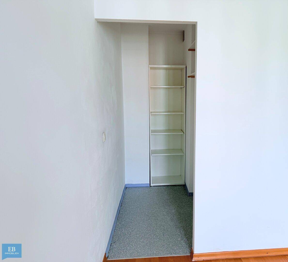 Praktischer Abstellraum mit Regalen und Teppichboden, ideal für zusätzlichen Stauraum.
