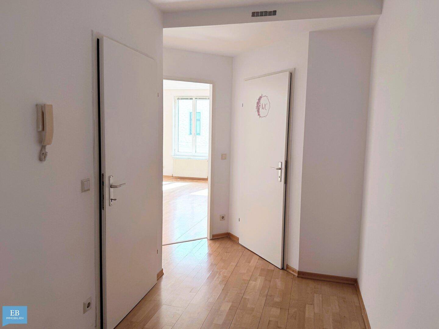 Heller Flur mit Parkettboden und Zugang zu verschiedenen Räumen der Wohnung.