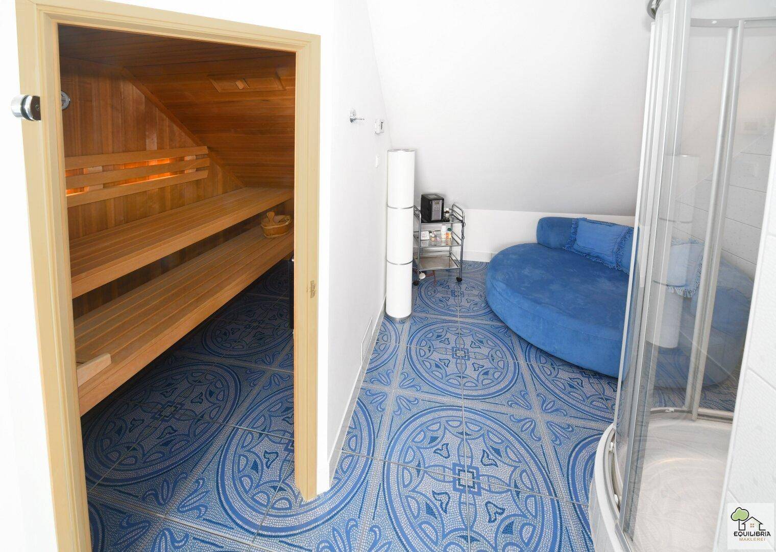 Badezimmer mit Sauna, Dusche und blauen Fliesen, ideal für Entspannung.