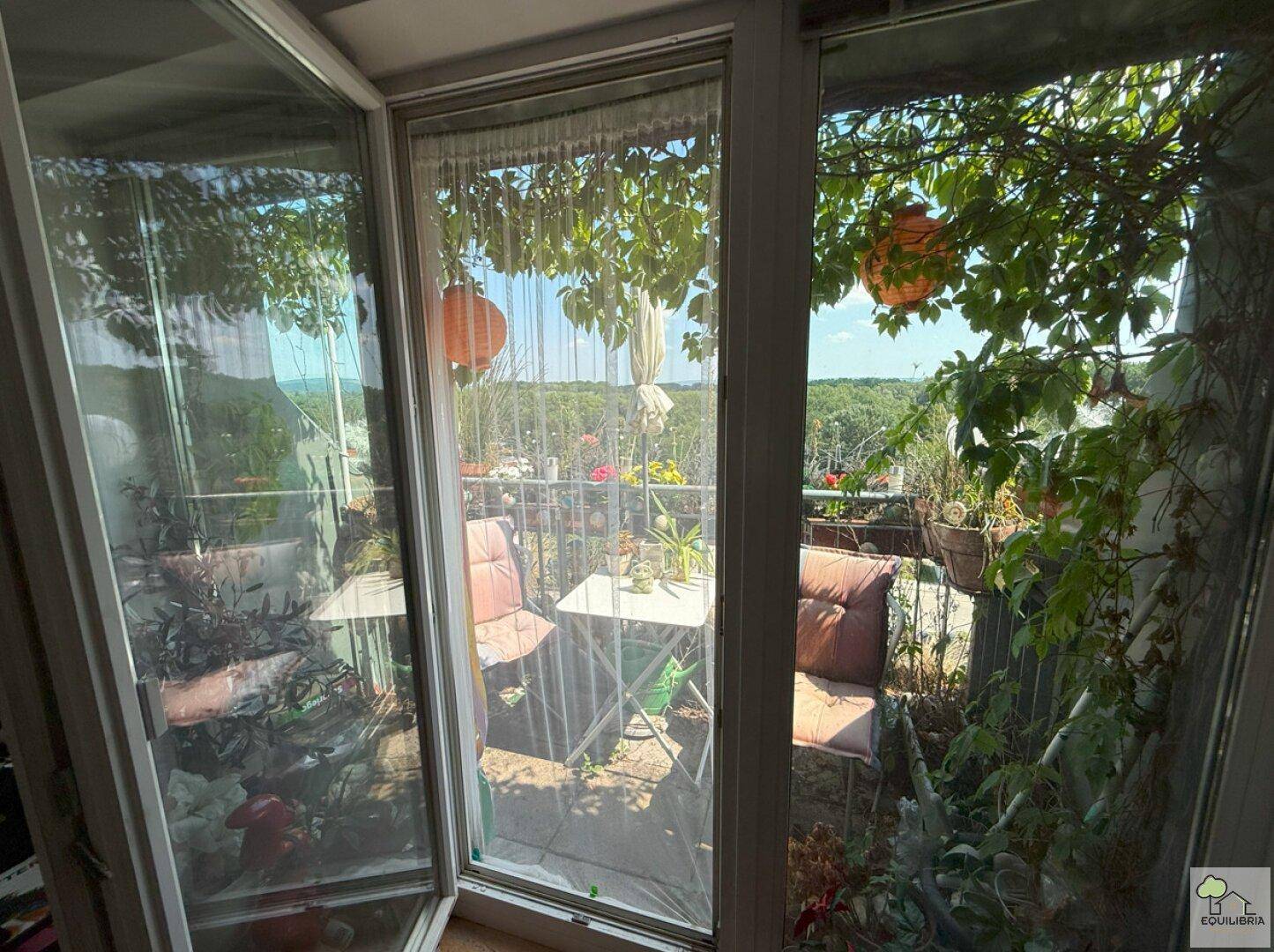 Gemütlicher Balkon mit Pflanzen und Sitzgelegenheiten, bietet eine weite Aussicht.