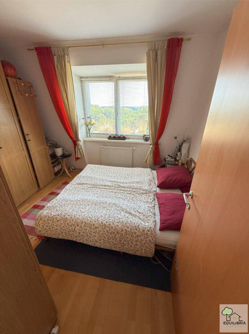Gemütliches Schlafzimmer mit Doppelbett, Dachschräge und Fenster mit Weitblick.