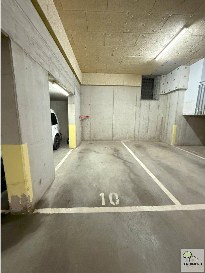 Tiefgaragenstellplatz Nummer 10 in einem modernen Parkhaus mit Betonwänden.