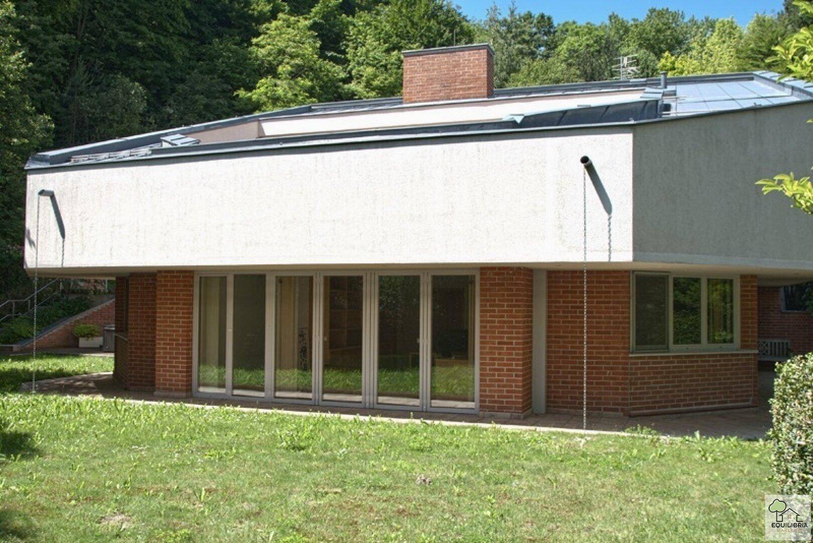 Moderne Architektur des Hauses mit Ziegelmauerwerk und großen Fensterfronten.