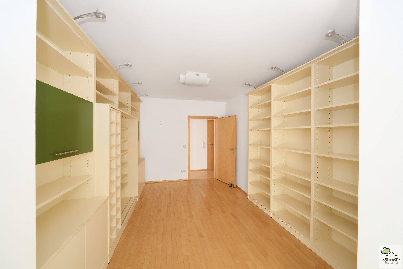 Geräumiger begehbarer Kleiderschrank mit vielen Regalen und Stauraum.