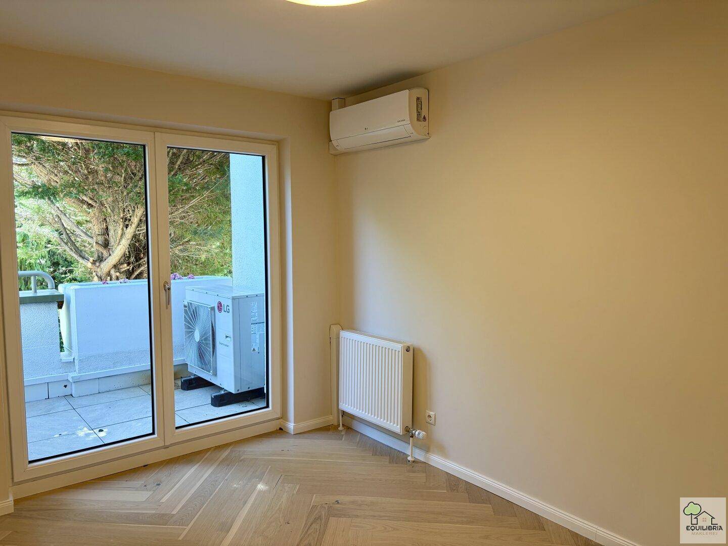 Schlafzimmer mit Zugang zum Balkon, Fischgrätparkett und Klimaanlage für angenehmes Klima.