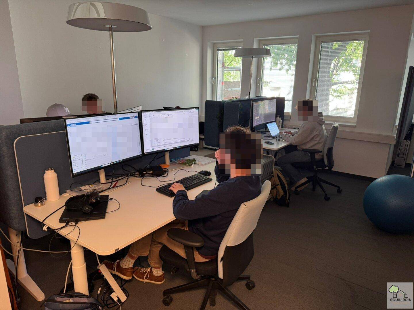Weiterer Blick in das Großraumbüro mit mehreren Arbeitsplätzen und natürlichem Lichteinfall.