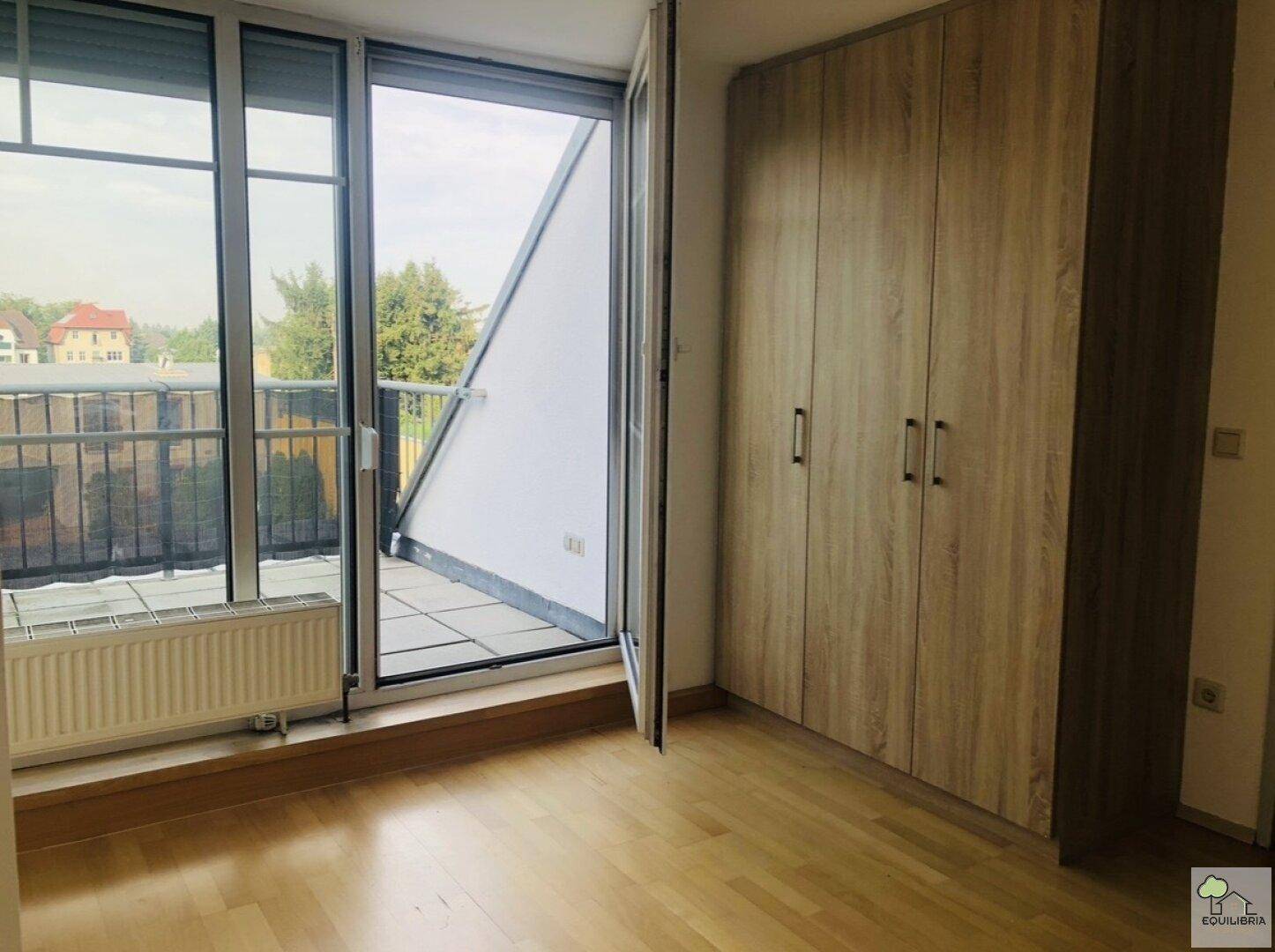 Schlafzimmer mit großem Einbauschrank und direktem Zugang zu einem Außenbereich.