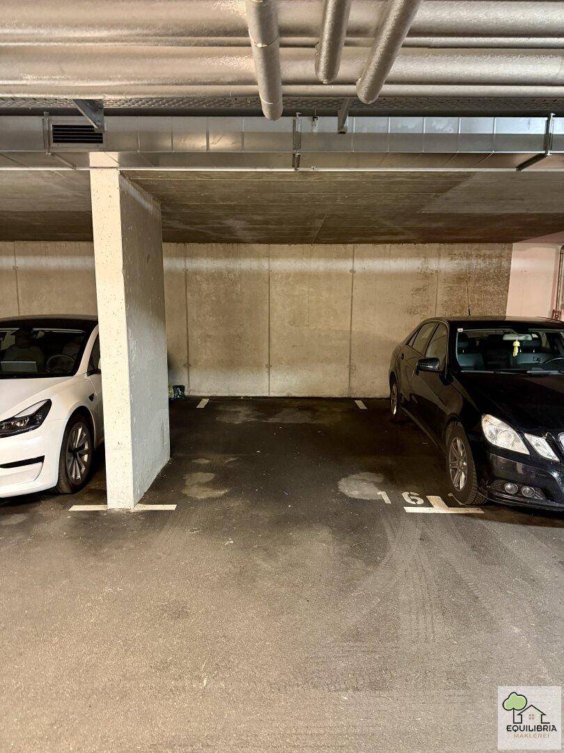 Tiefgarage mit zwei Stellplätzen und Betonwänden, bietet sicheren Parkraum für Fahrzeuge.