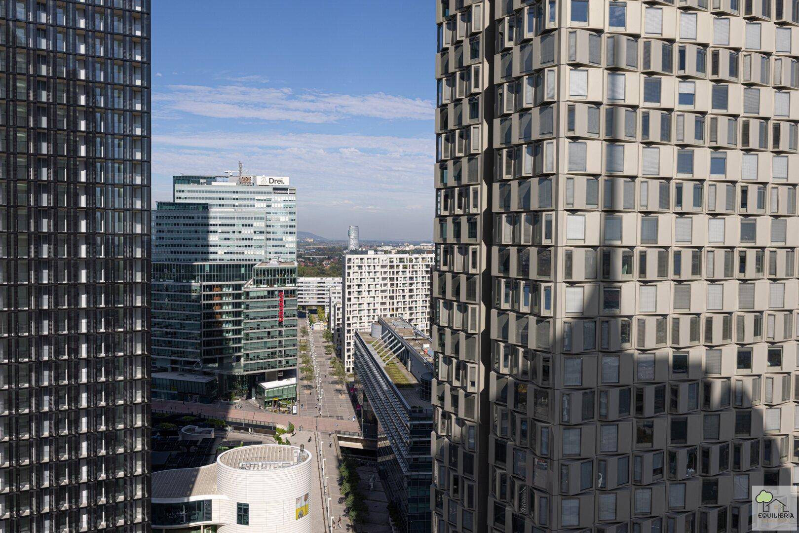 Panoramablick auf moderne Hochhäuser und die städtische Skyline unter blauem Himmel.