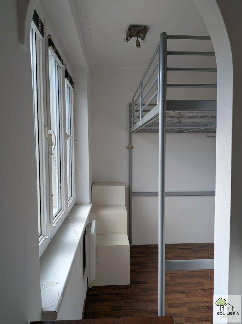 Schlafzimmer mit Hochbett, Holzboden und großen Fenstern für viel Tageslicht.