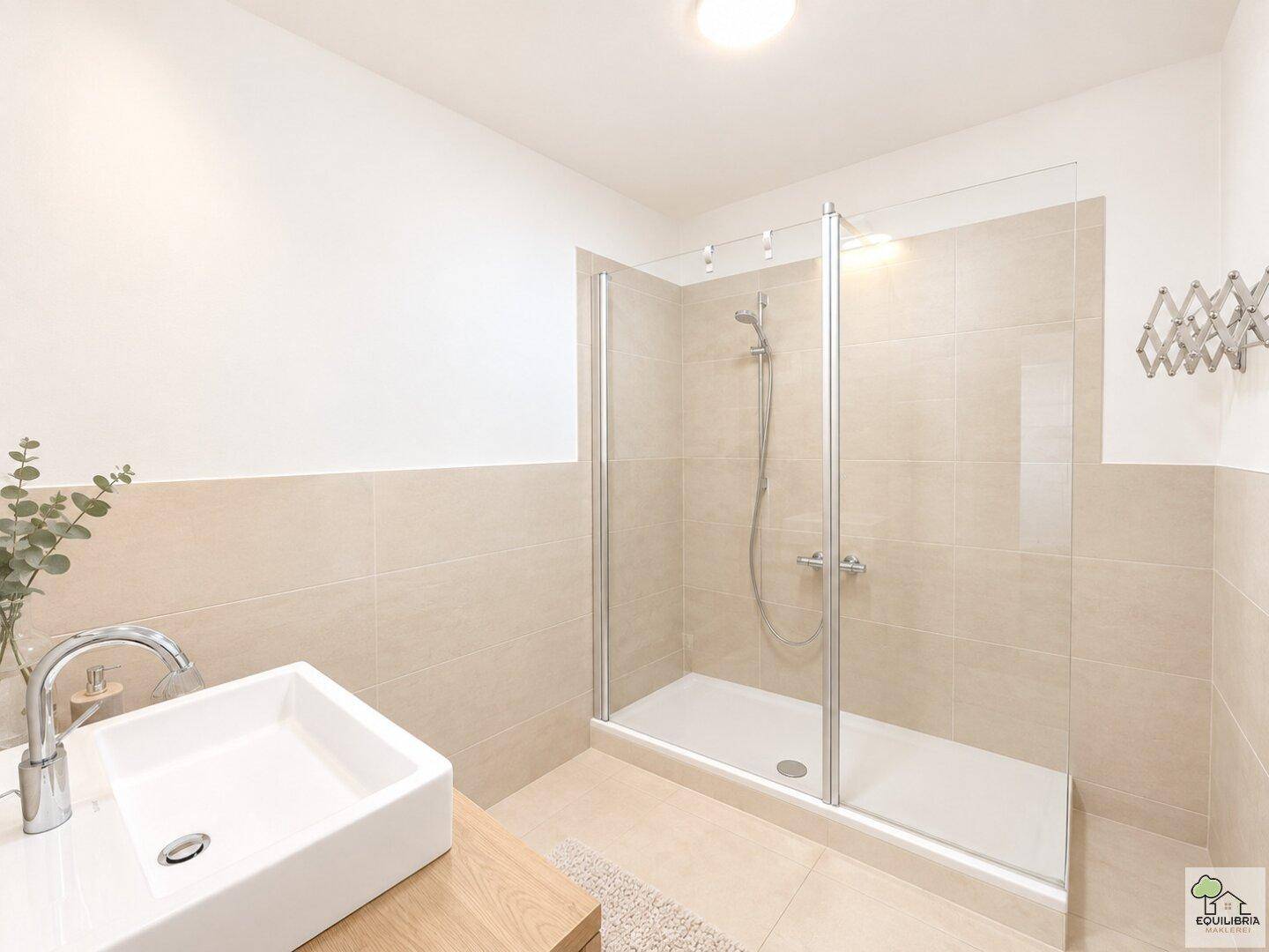 Modernes Badezimmer mit begehbarer Dusche, beigefarbenen Fliesen und Einzelwaschbecken.