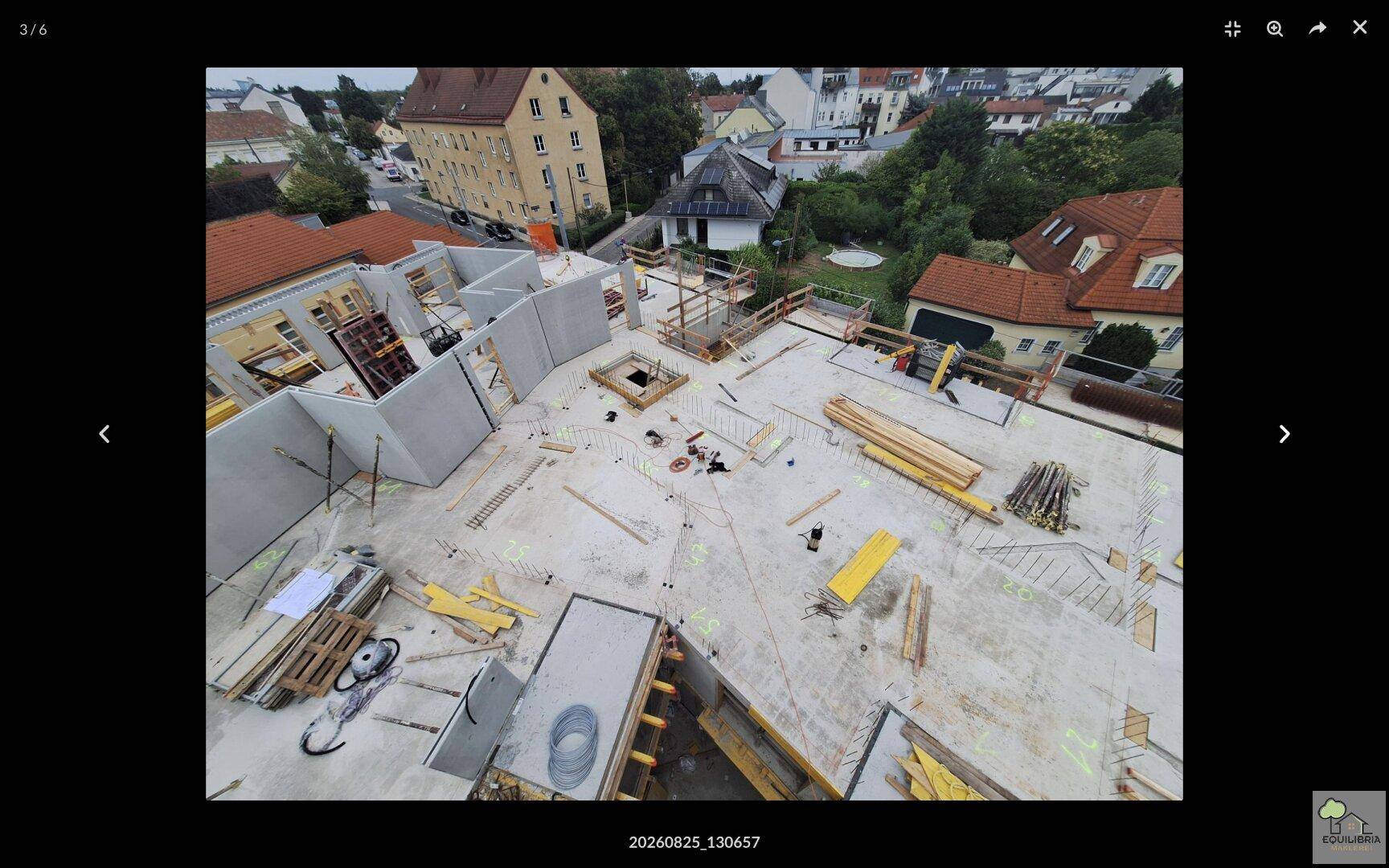 Baustellenansicht von oben mit Betonplatten und vorbereiteten Wänden für den weiteren Bau.