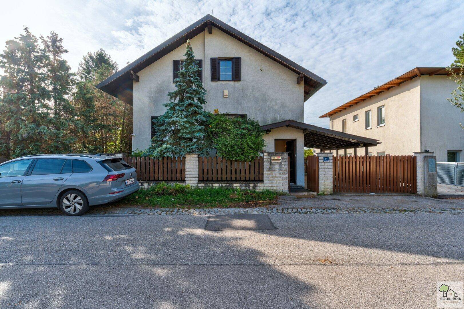 Vorderansicht des Einfamilienhauses von der Straße aus mit Carport und Vorgarten.