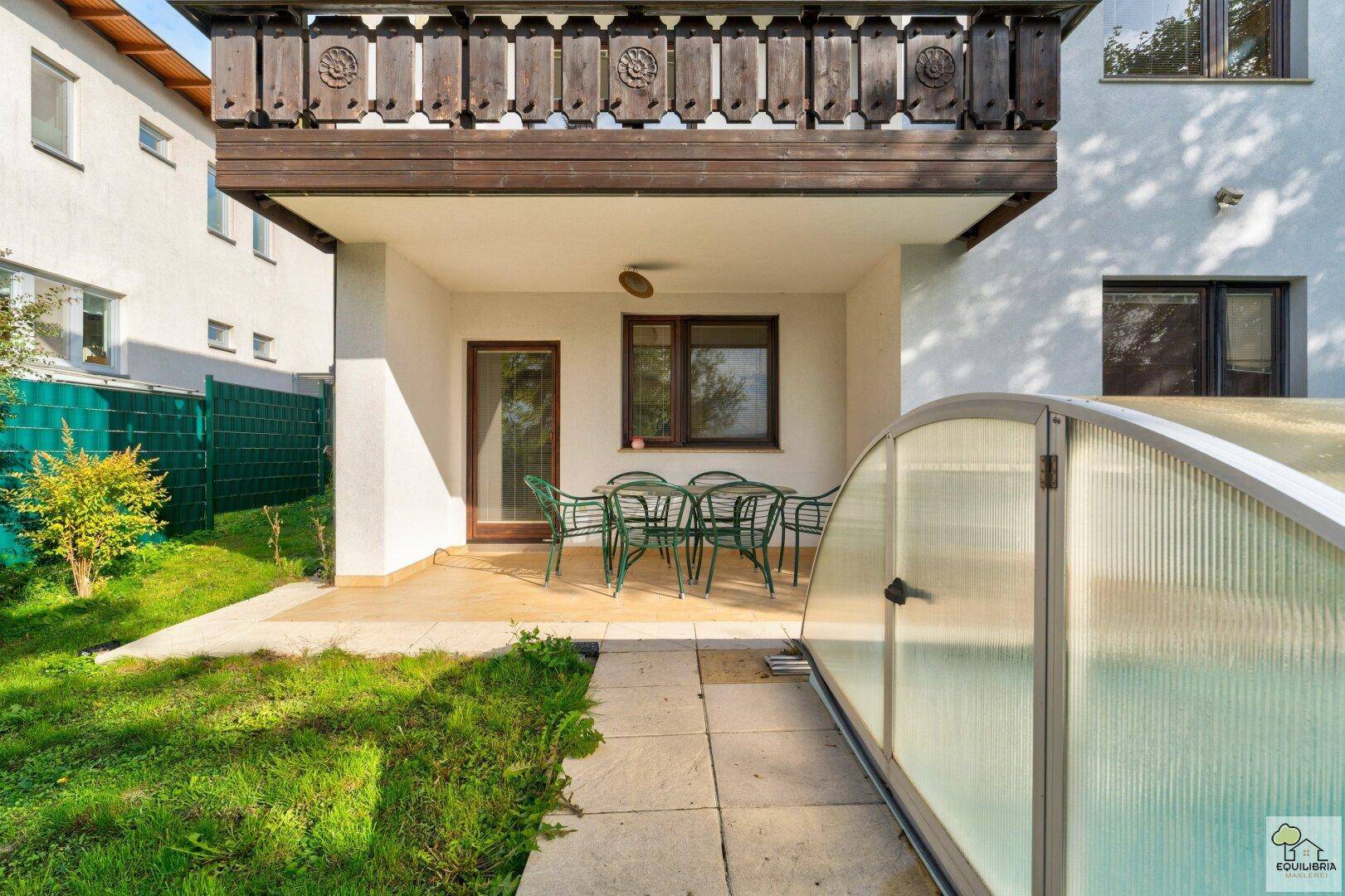 Überdachte Terrasse mit Gartenmöbeln und direktem Zugang zum Poolbereich.