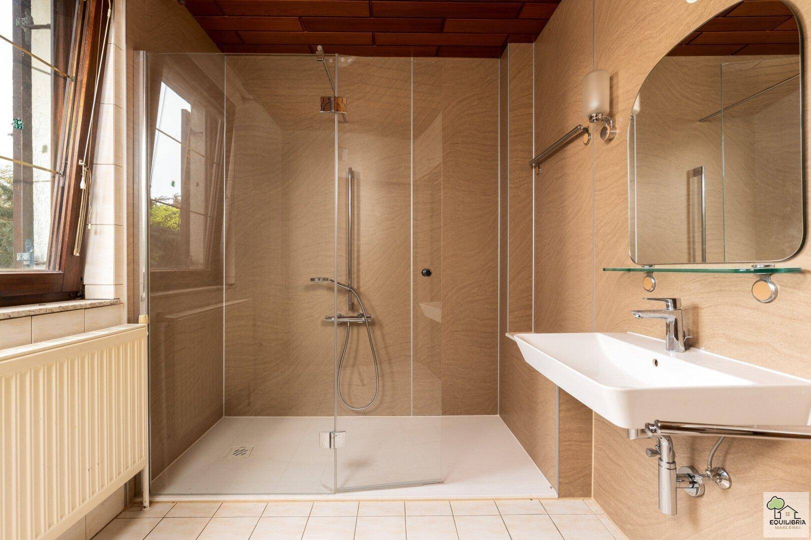 Modernes Badezimmer mit ebenerdiger Dusche, Waschbecken und Fenster.