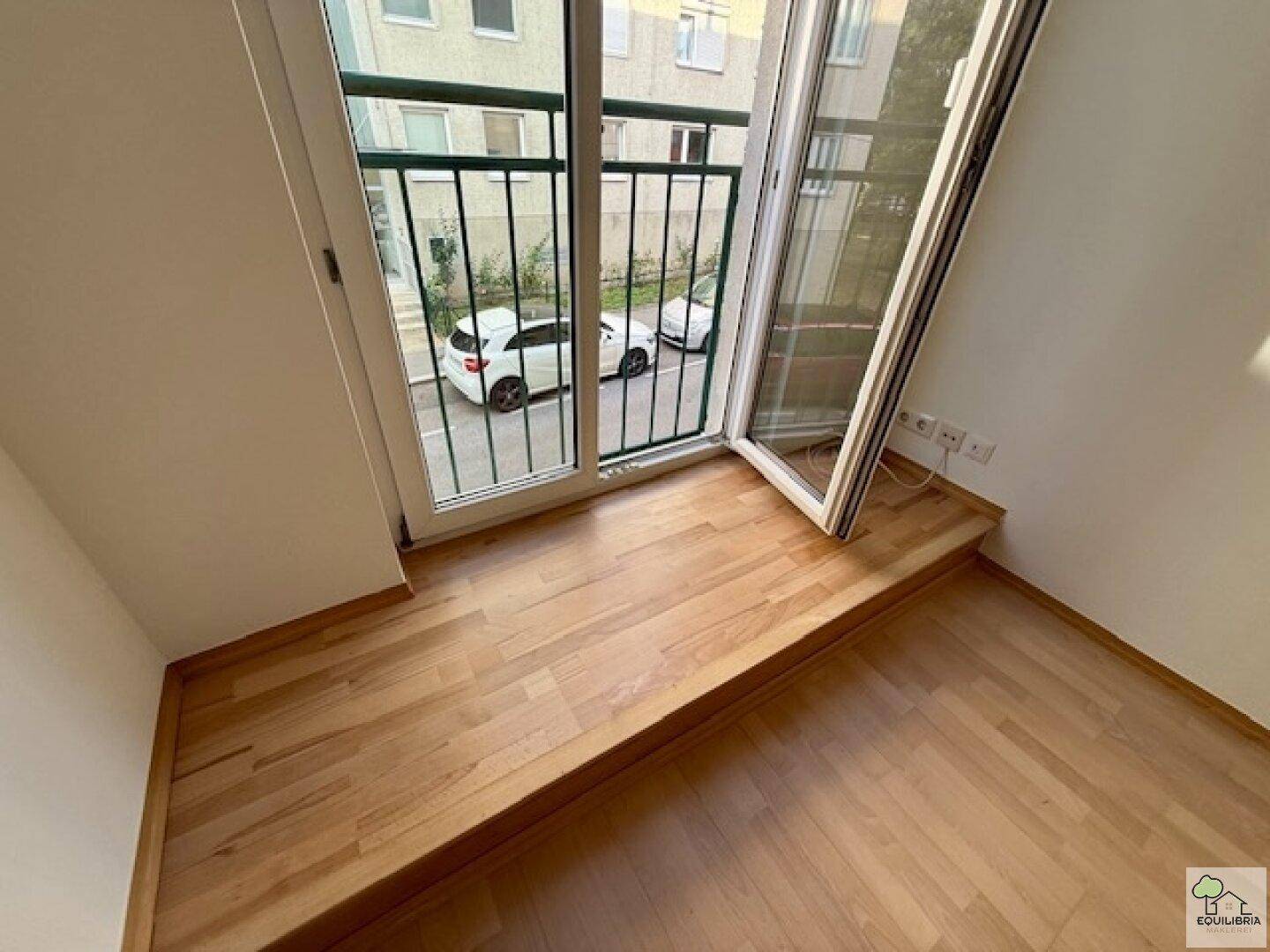 Innenansicht mit Zugang zu einem kleinen Balkon, der einen Blick auf die Straße bietet.