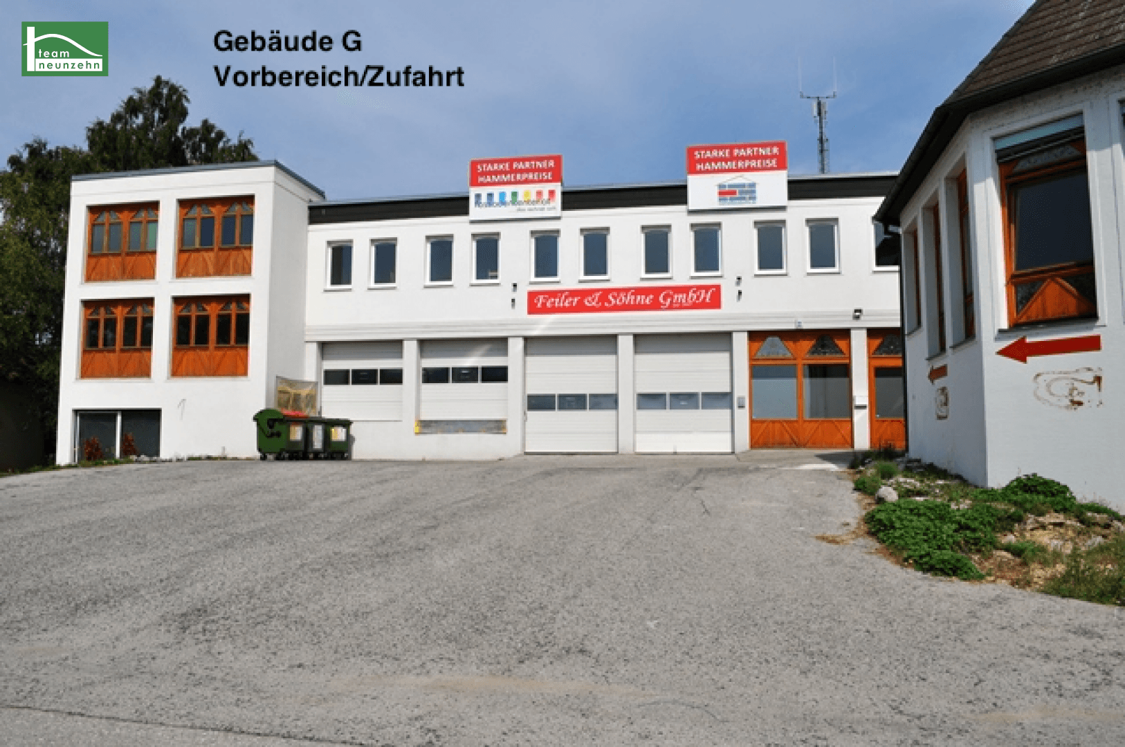 Vorderansicht eines Gewerbegebäudes mit mehreren Garagentoren und Werbeschildern an der Fassade.