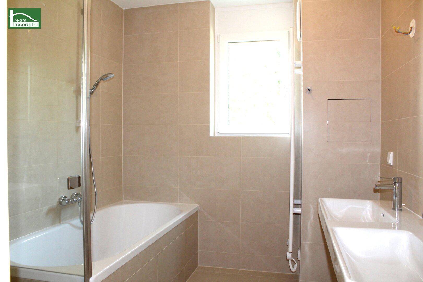 Modernes Badezimmer mit Badewanne, Dusche, Einzelwaschbecken und Fenster.