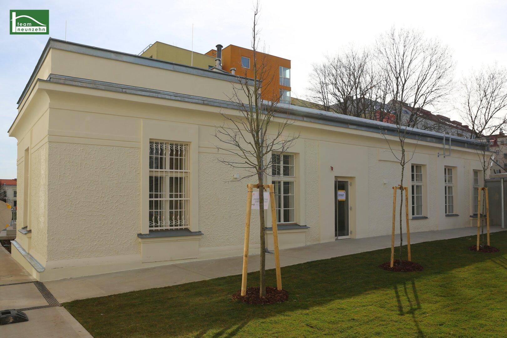 Klassisches einstöckiges Gebäude mit heller Fassade und gepflegtem Vorgarten.