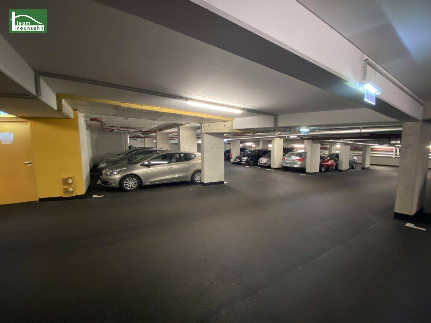 Tiefgarage mit mehreren Stellplätzen und guter Beleuchtung für Fahrzeuge.