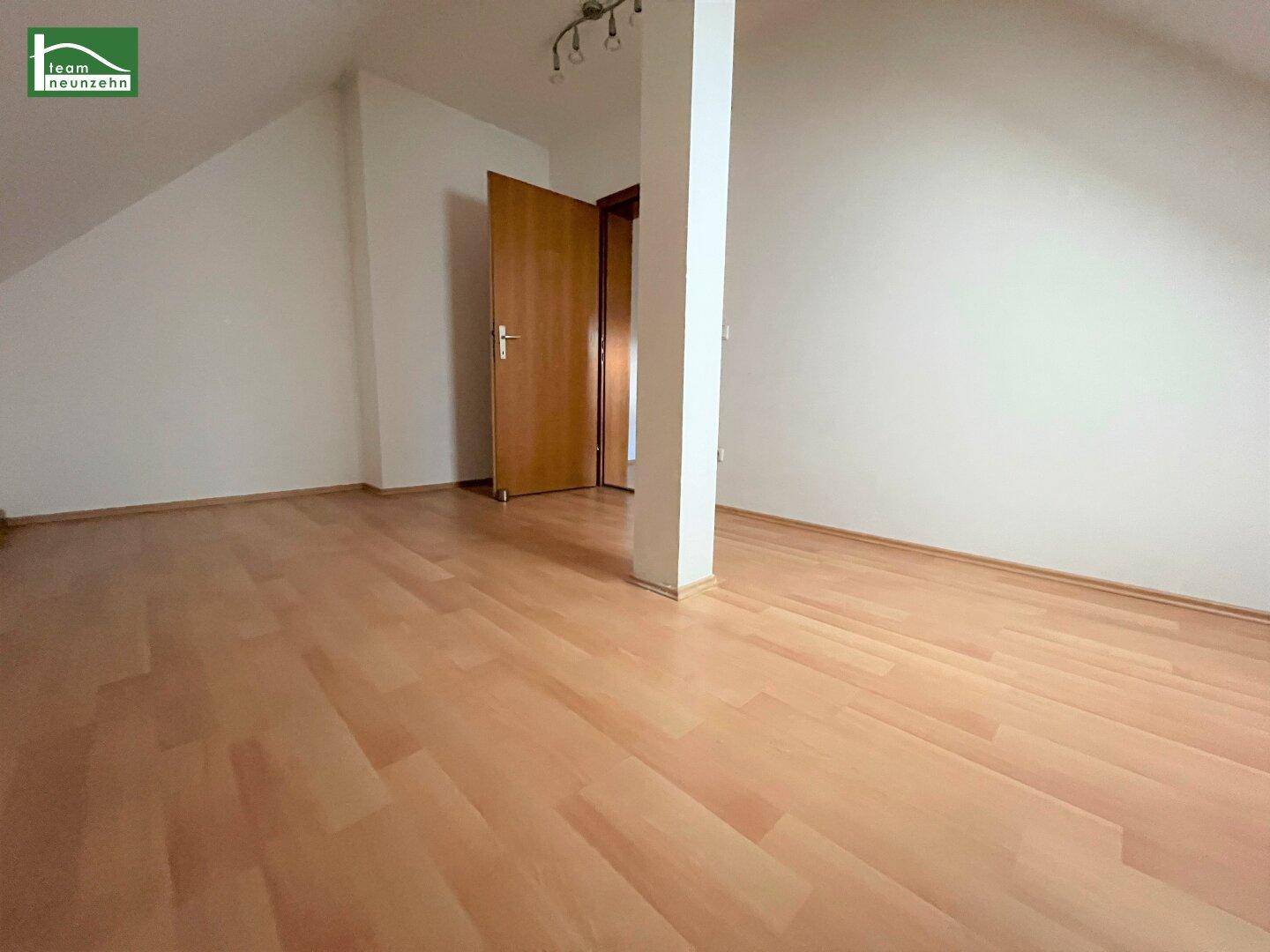 Heller Raum im Dachgeschoss mit Dachschrägen und Laminatboden, bereit zur individuellen Gestaltung.