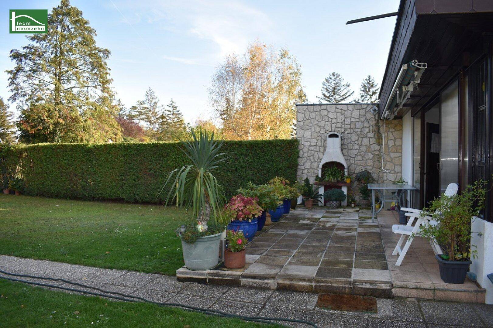 Geräumige Terrasse mit gepflastertem Boden und einem gemauerten Grillplatz für gemütliche Abende.