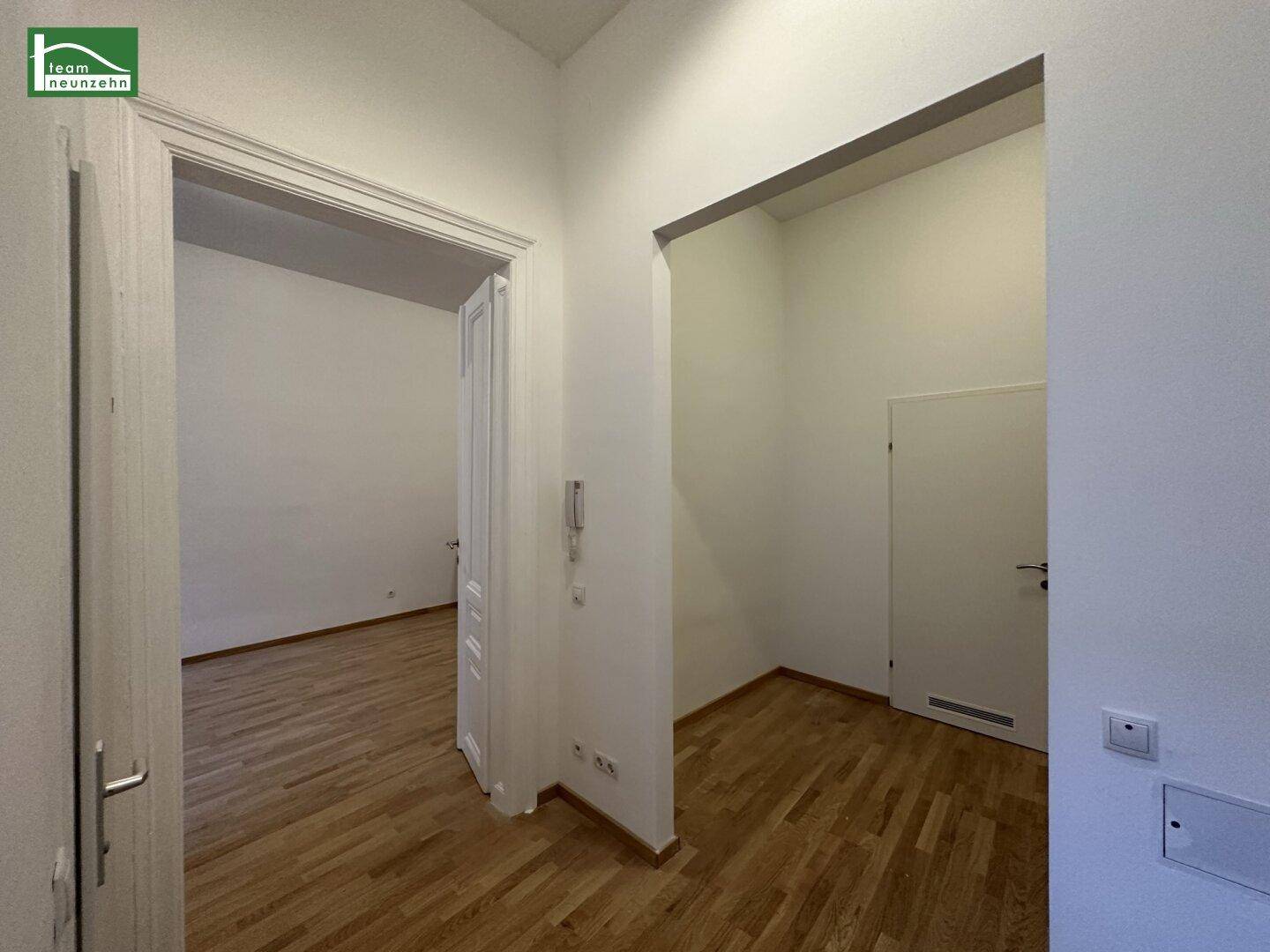 Heller Eingangsbereich mit Parkettboden und Zugang zu den angrenzenden Zimmern der Wohnung.