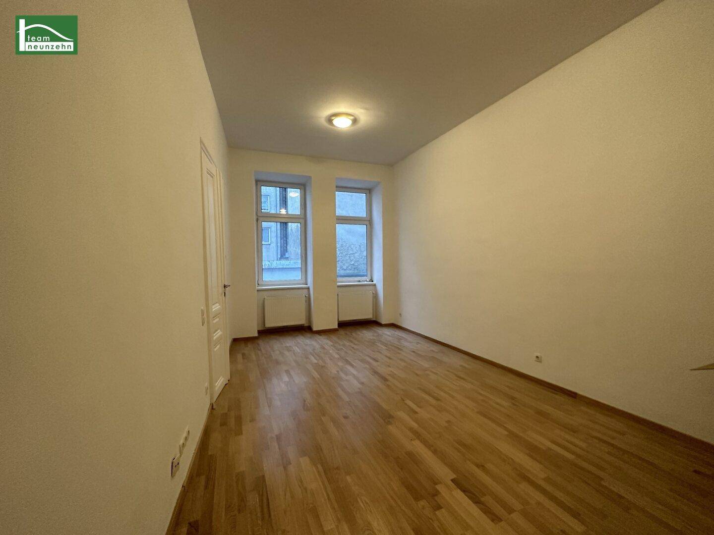 Geräumiges Zimmer mit hellem Parkettboden und hohen Decken, bereit zur individuellen Gestaltung.