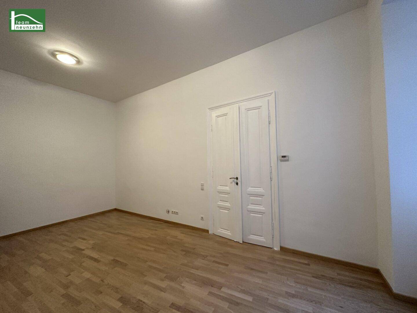 Freundliches Zimmer mit klassischer Flügeltür und Parkettboden, vielseitig nutzbar als Wohn- oder Schlafzimmer.
