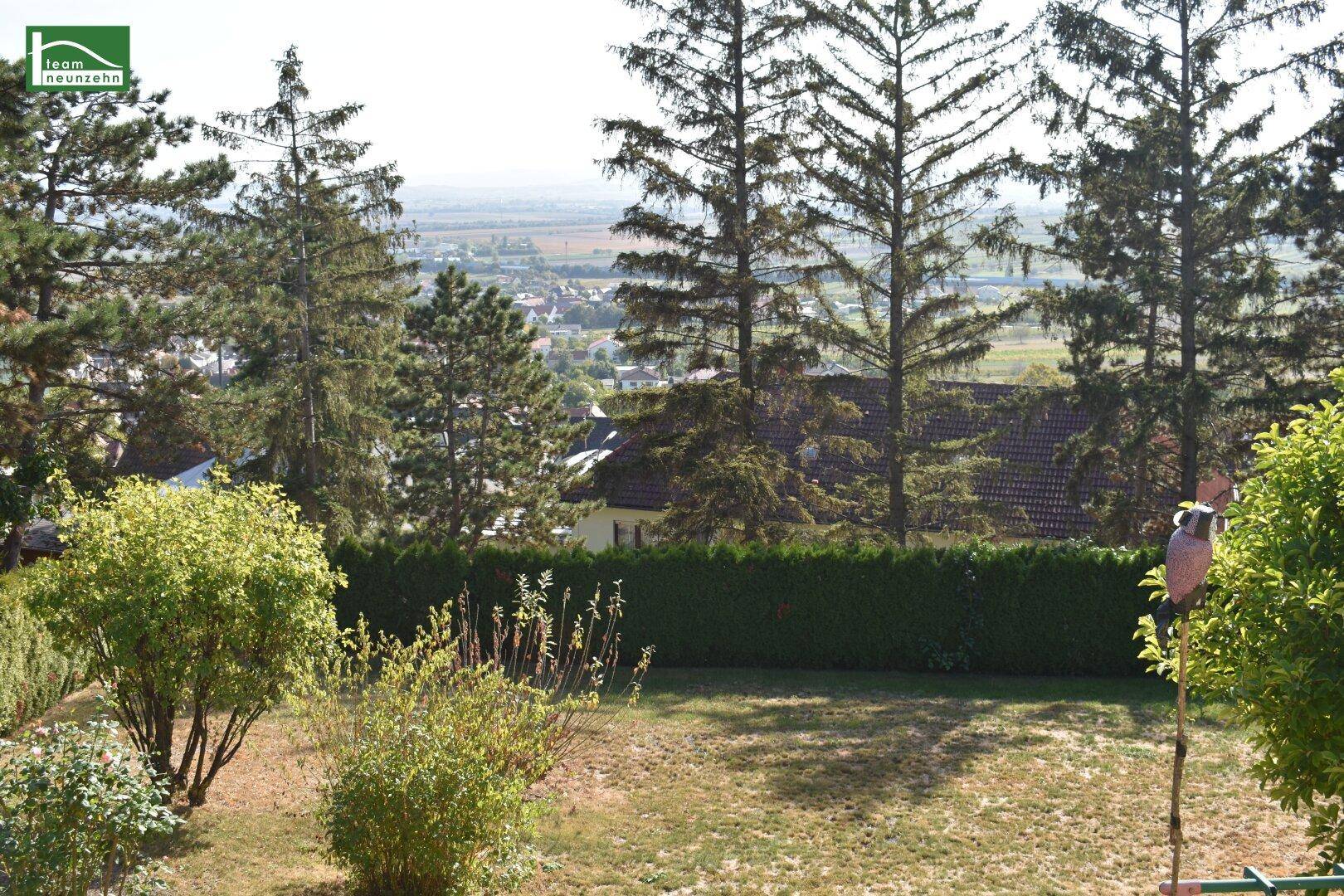 Gartenbereich mit weitem Blick über die Landschaft und umliegende Bebauung.