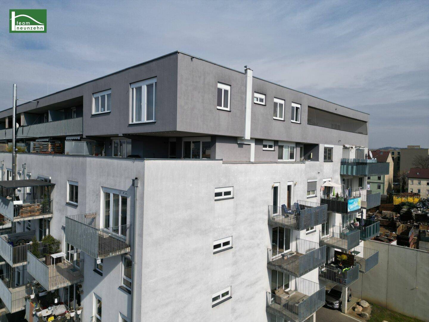 Moderne Fassade des Wohngebäudes mit zahlreichen Balkonen und klaren Linien.