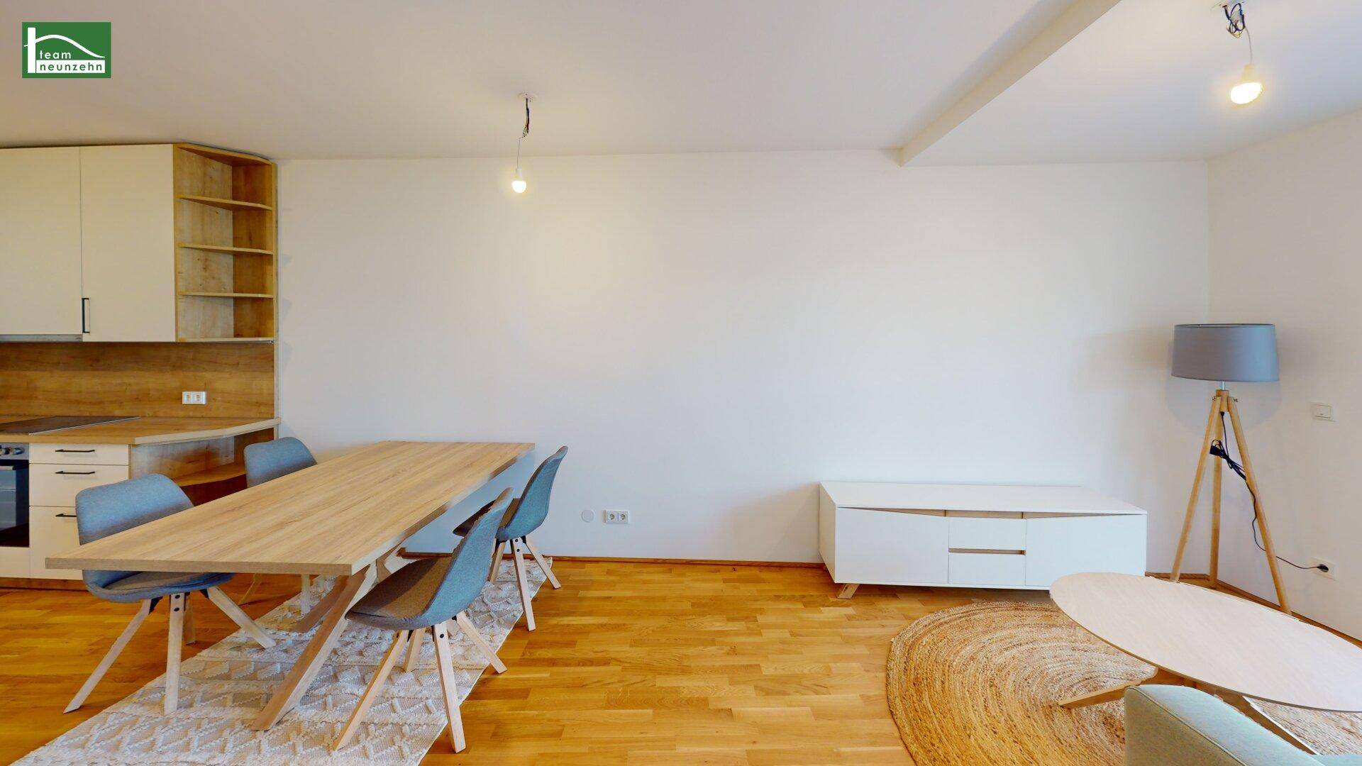 Offener Wohn- und Essbereich mit Holztisch, modernen Stühlen und Parkettboden.