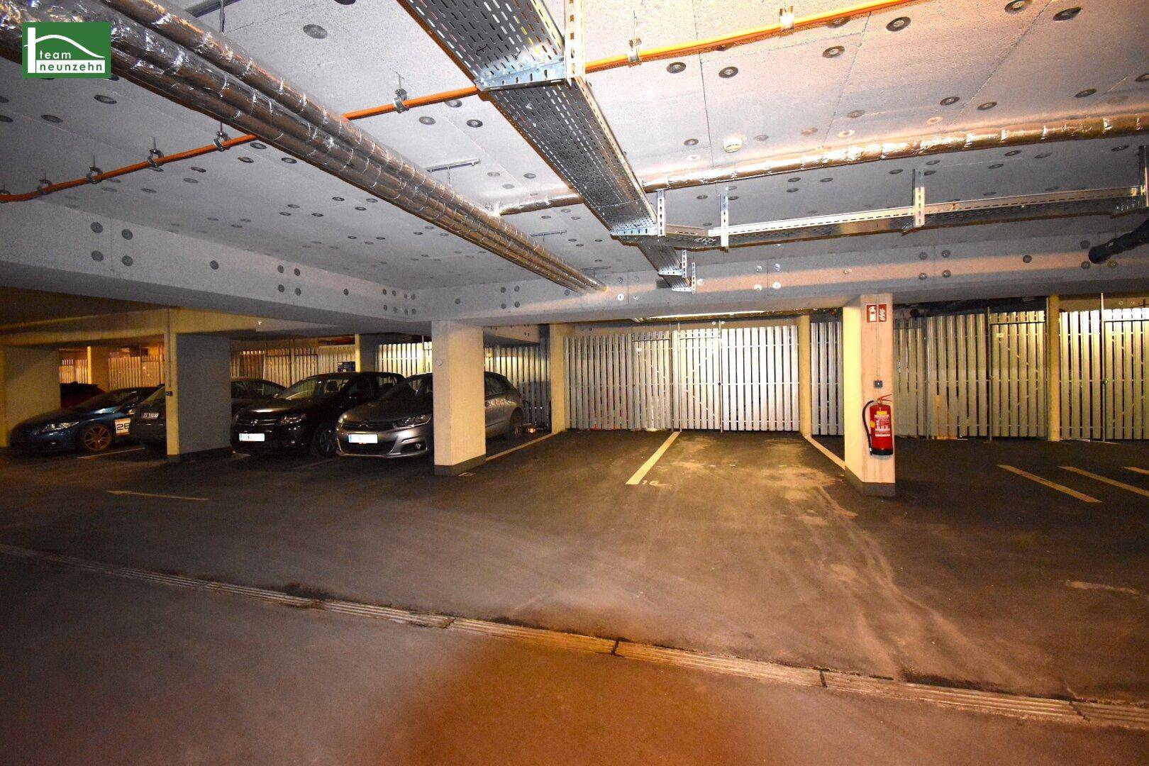 Tiefgarage mit mehreren Stellplätzen und geparkten Fahrzeugen.