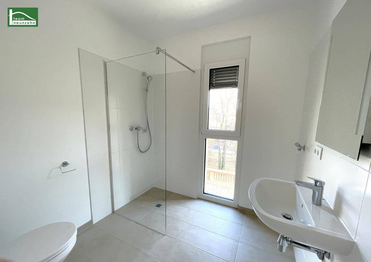 Modernes Badezimmer mit ebenerdiger Dusche, Einzelwaschbecken und Fenster für Tageslicht.