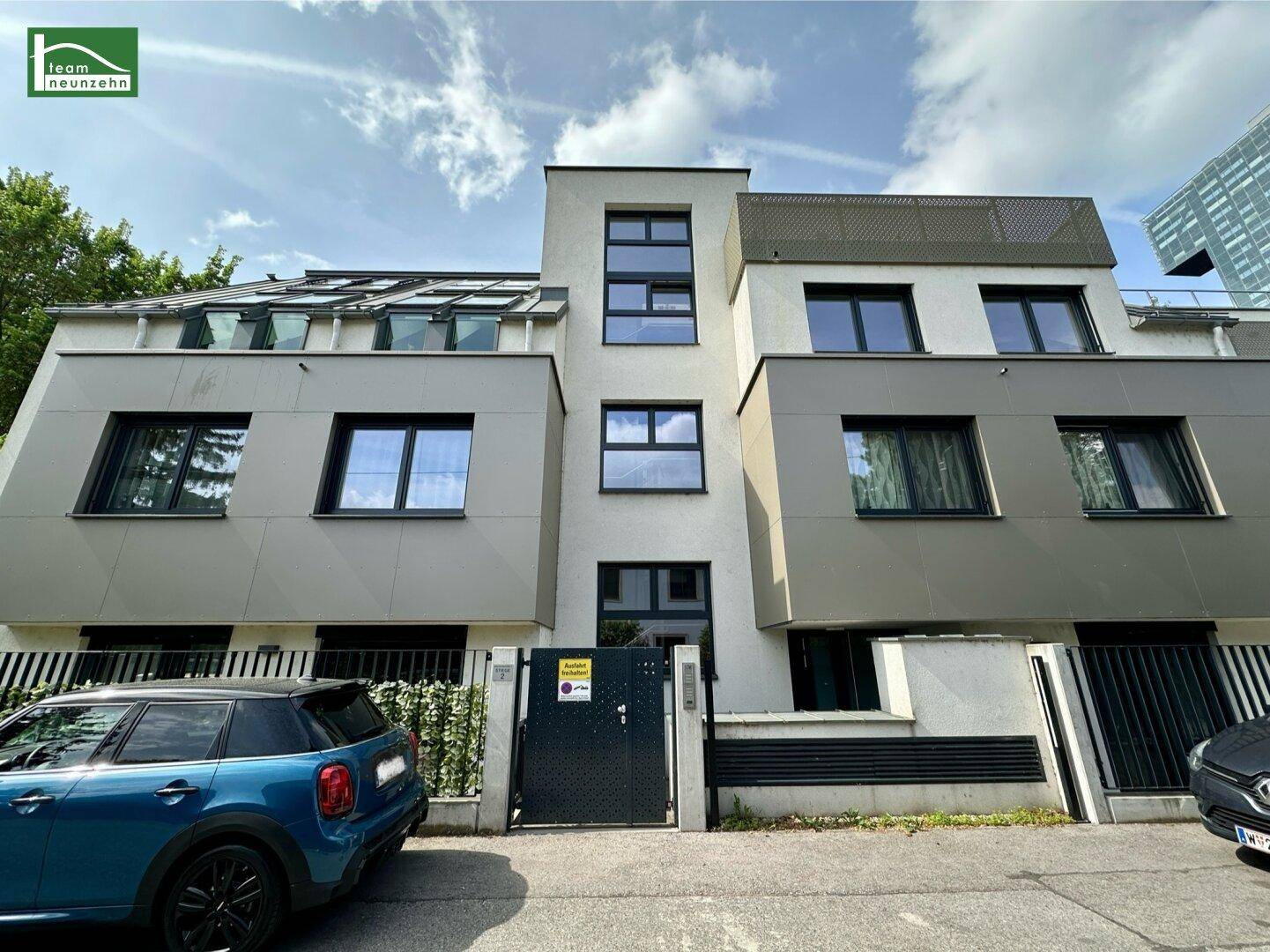 Moderne Gebäudefassade mit klaren Linien und großen Fenstern an einer Straße.