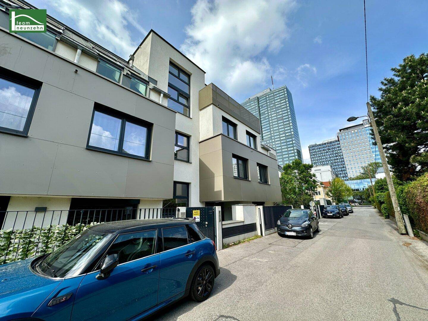 Modernes Wohngebäude an einer Straße mit Blick auf die Stadtkulisse.