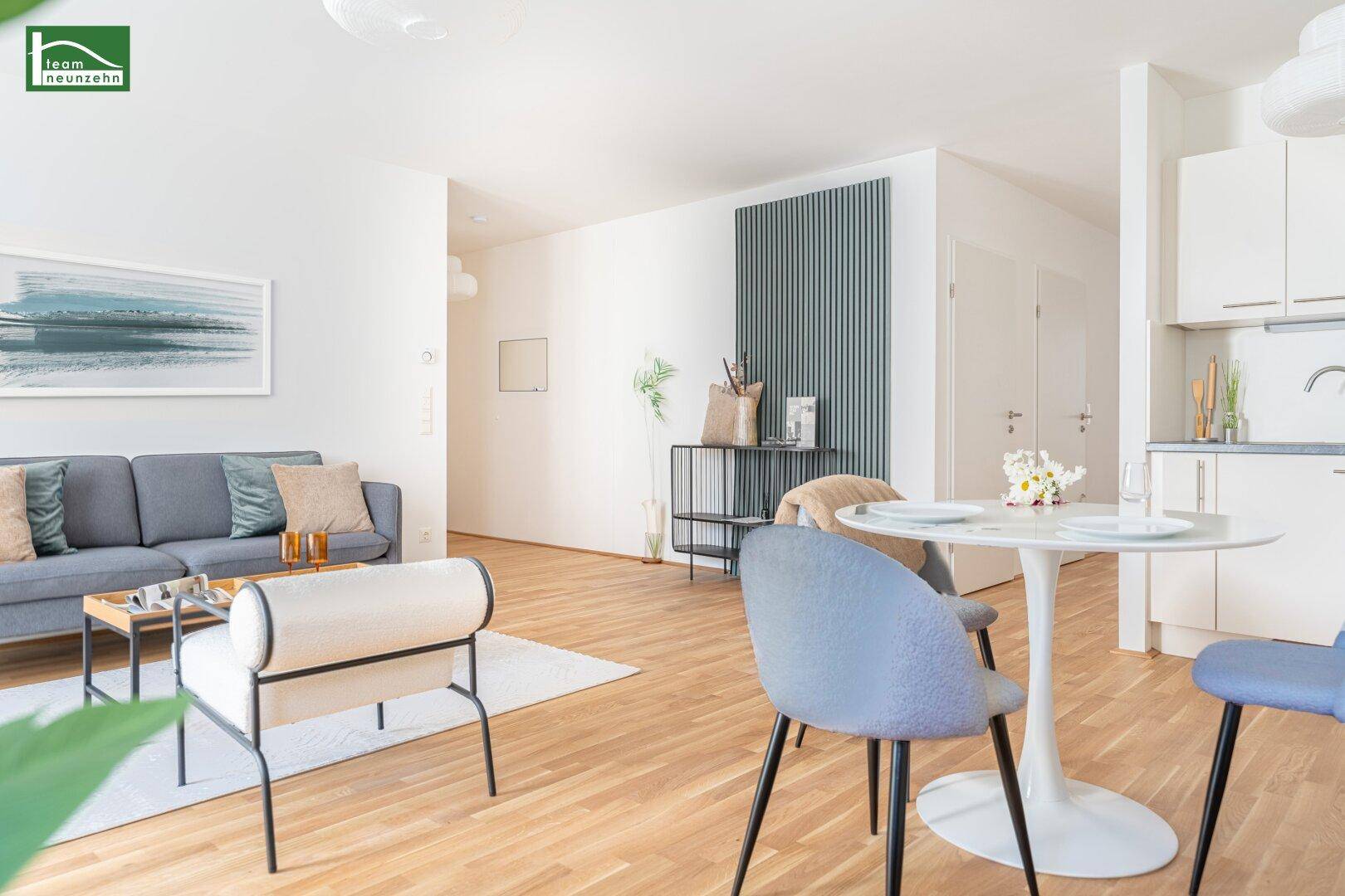 Offener Wohn- und Essbereich mit Sofa, Esstisch und integrierter Küchenzeile.