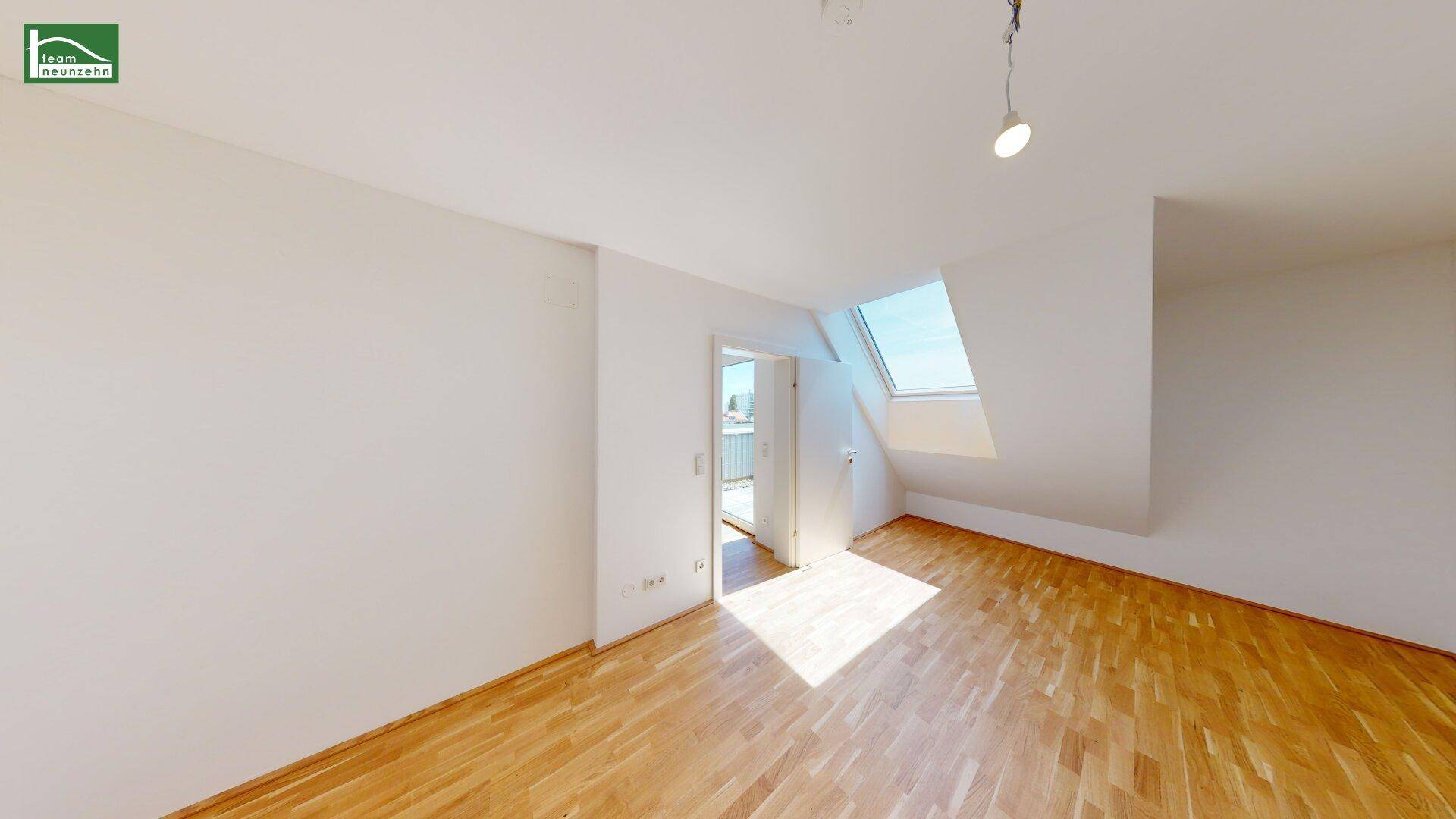 Helles Schlafzimmer im Dachgeschoss mit Dachfenster und Parkettboden, ideal für ein gemütliches Ambiente.