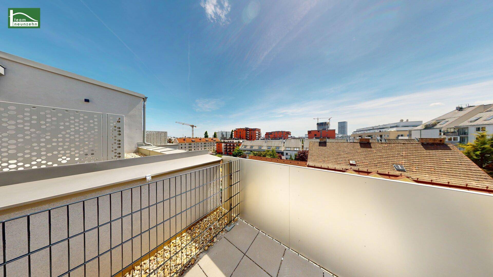Dachterrasse mit weitem Blick über die Stadt und umliegende Gebäude, perfekt für urbane Entspannung.