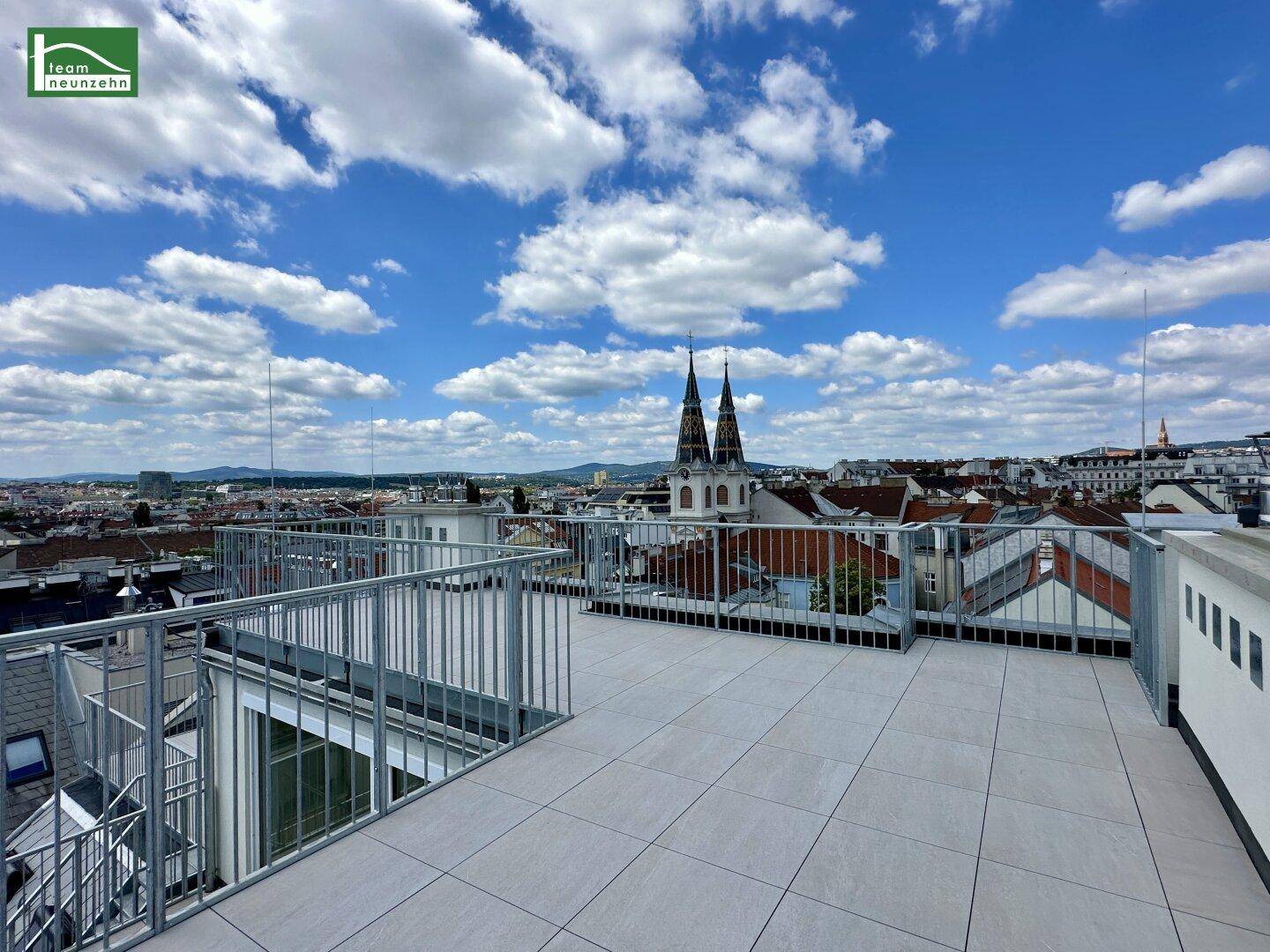 Offene Dachterrasse mit weitem Blick über die Dächer der Stadt und die umliegende Landschaft.