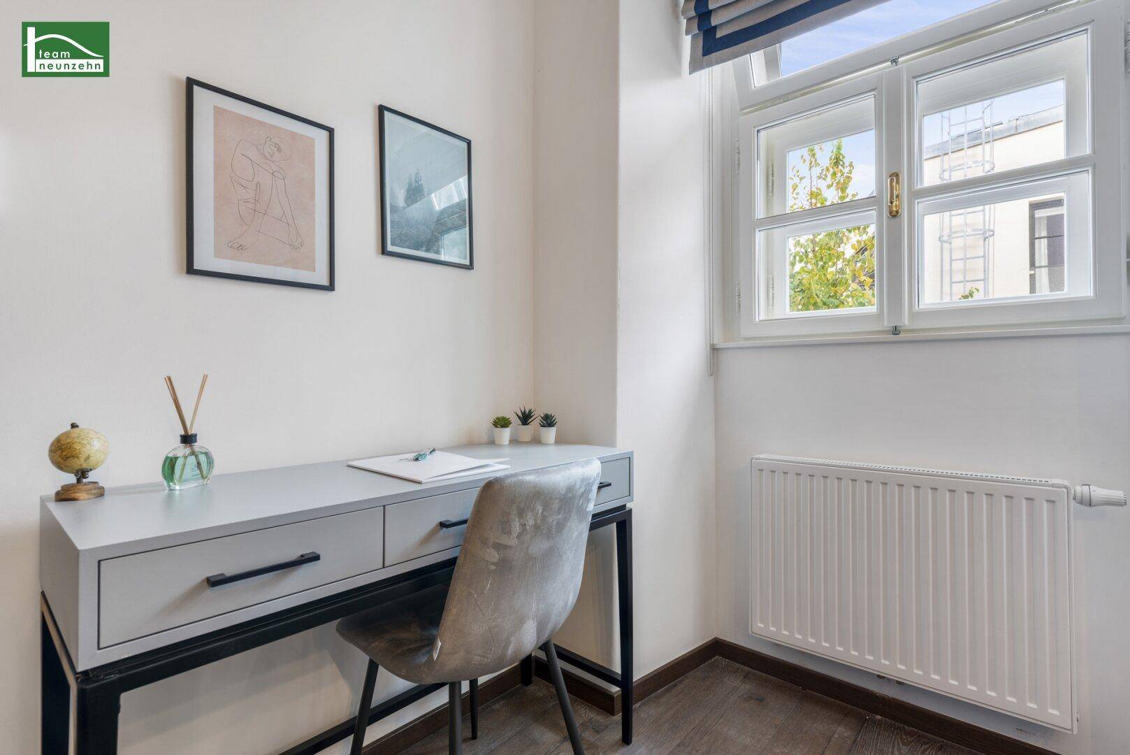 Kleiner Arbeitsbereich mit Schreibtisch und Fenster, ideal für Home-Office-Tätigkeiten.