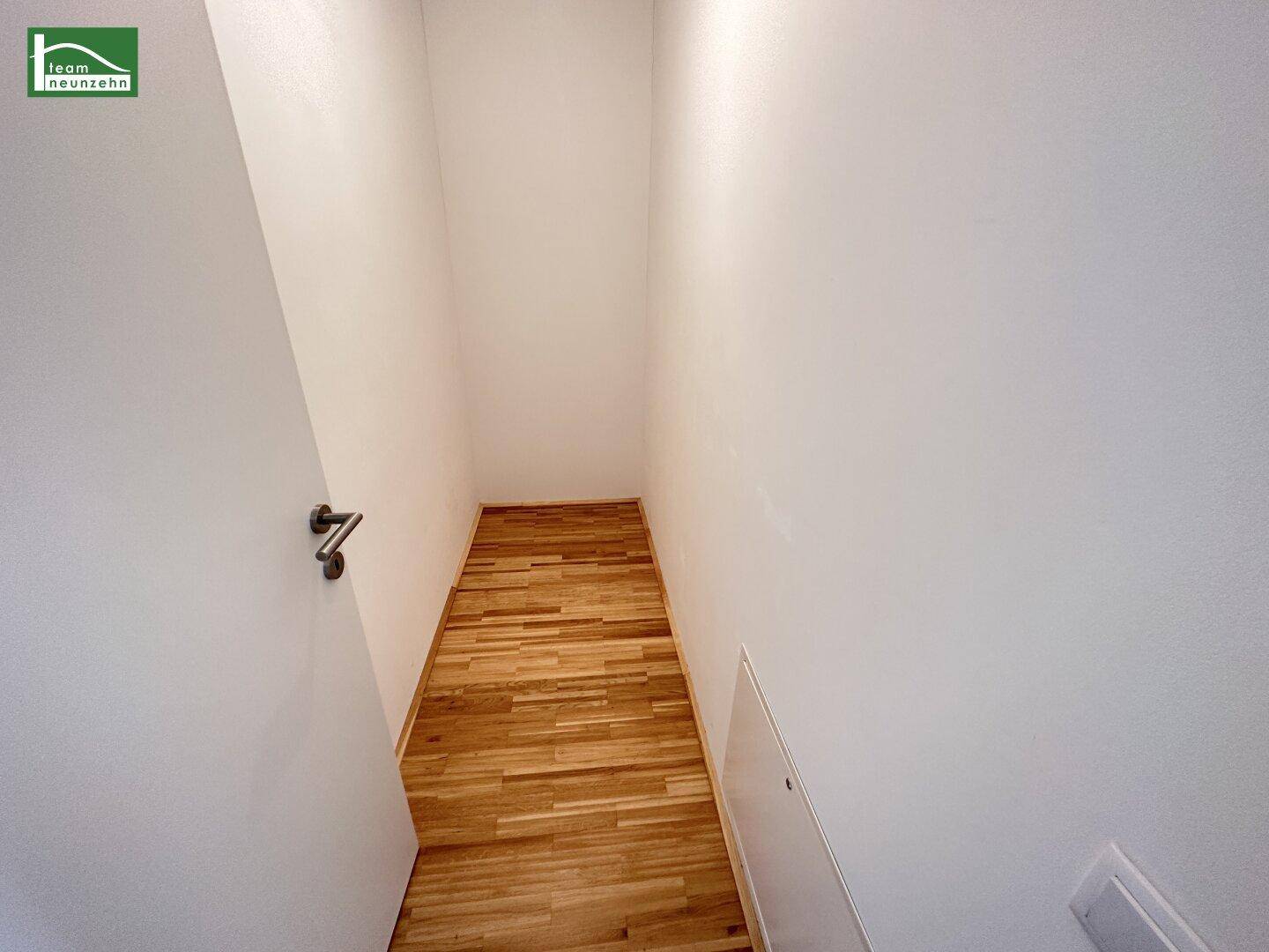 Kleiner, leerer Abstellraum mit Holzboden, ideal für zusätzlichen Stauraum im Apartment.