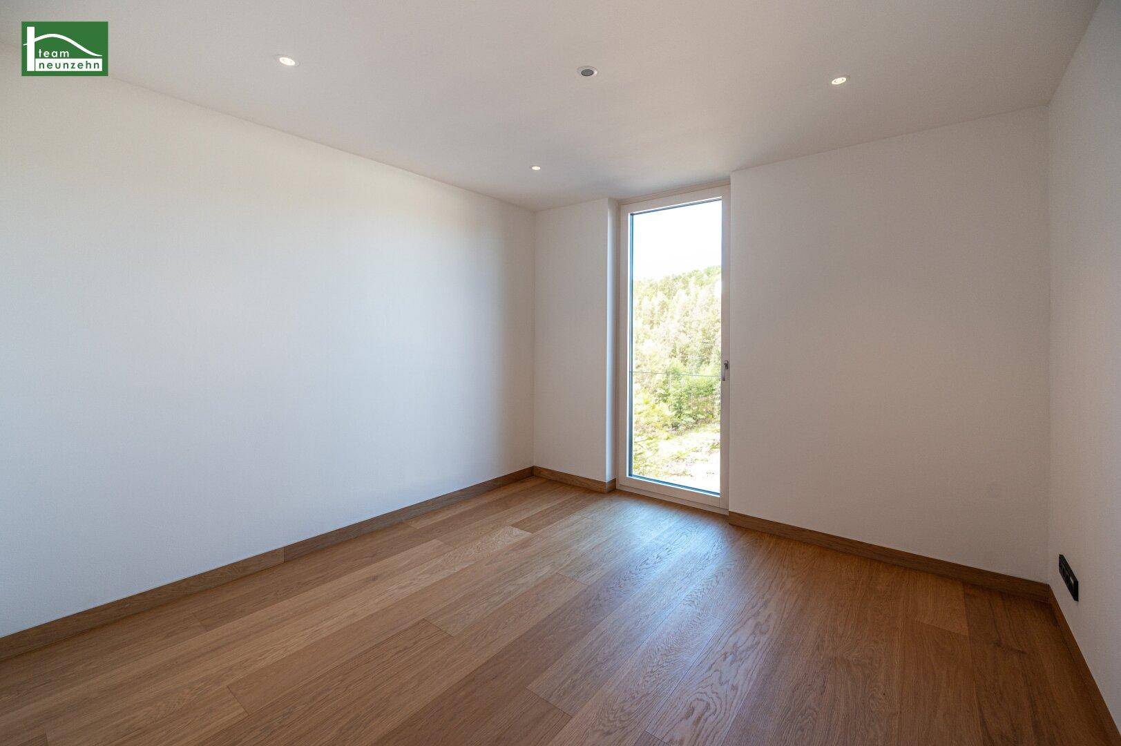 Geräumiges Schlafzimmer mit Eichenparkett und großen Fenstern, die eine helle und freundliche Atmosphäre schaffen.