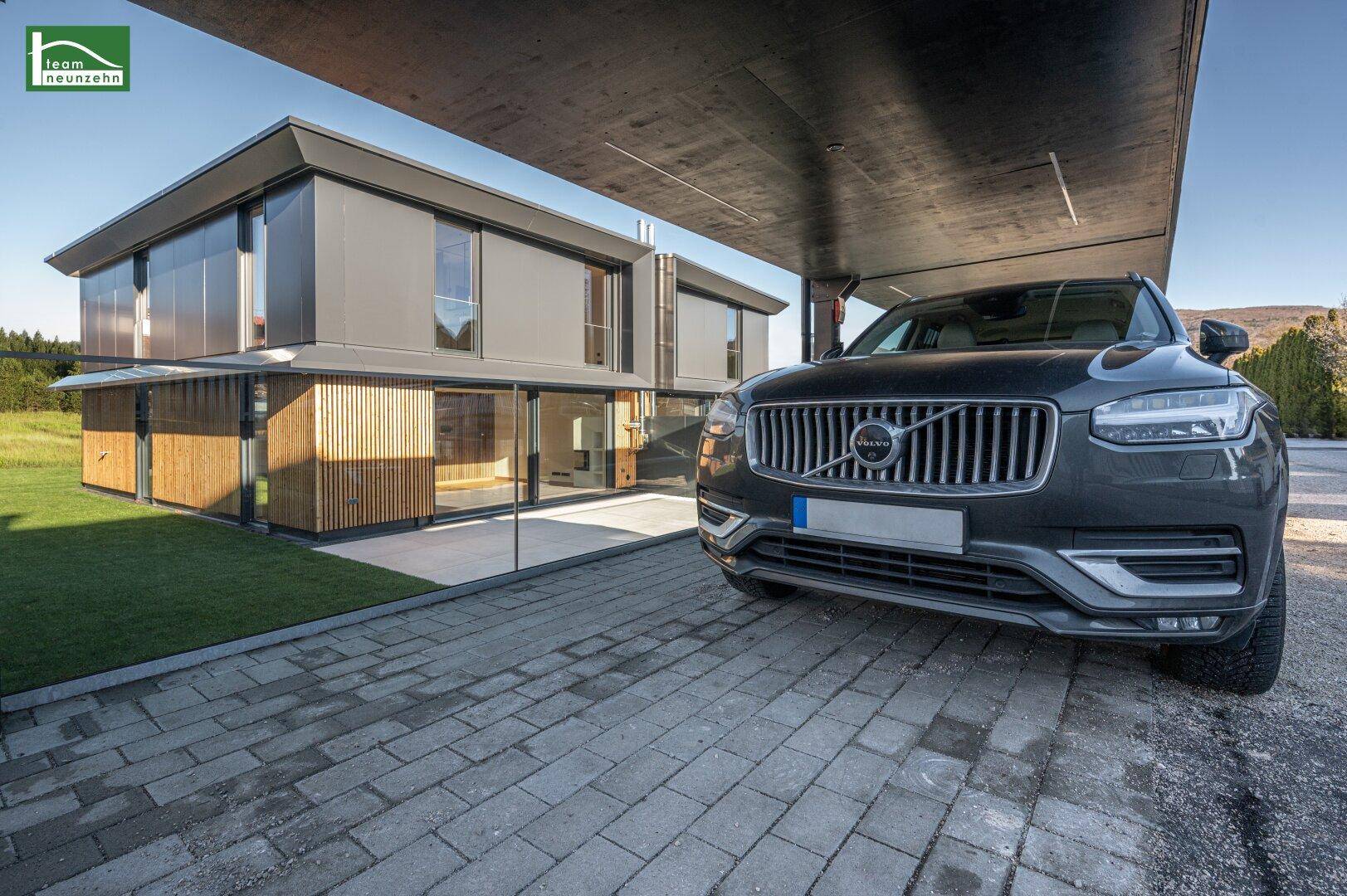 Moderne Architektur des Hauses mit Carport und gepflasterter Einfahrt.