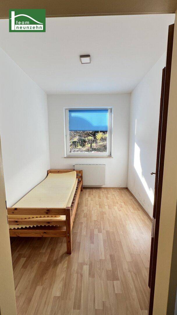 Kleines Schlafzimmer oder Gästezimmer mit Einzelbett und Laminatboden.