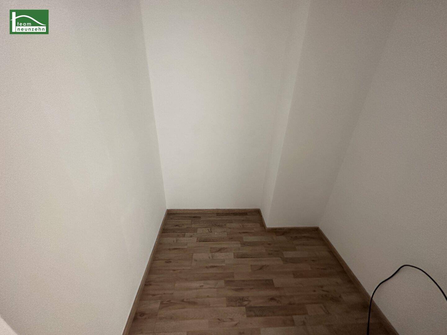 Leerer Raum mit Holzboden und weißen Wänden, nutzbar als Abstellraum oder begehbarer Kleiderschrank.