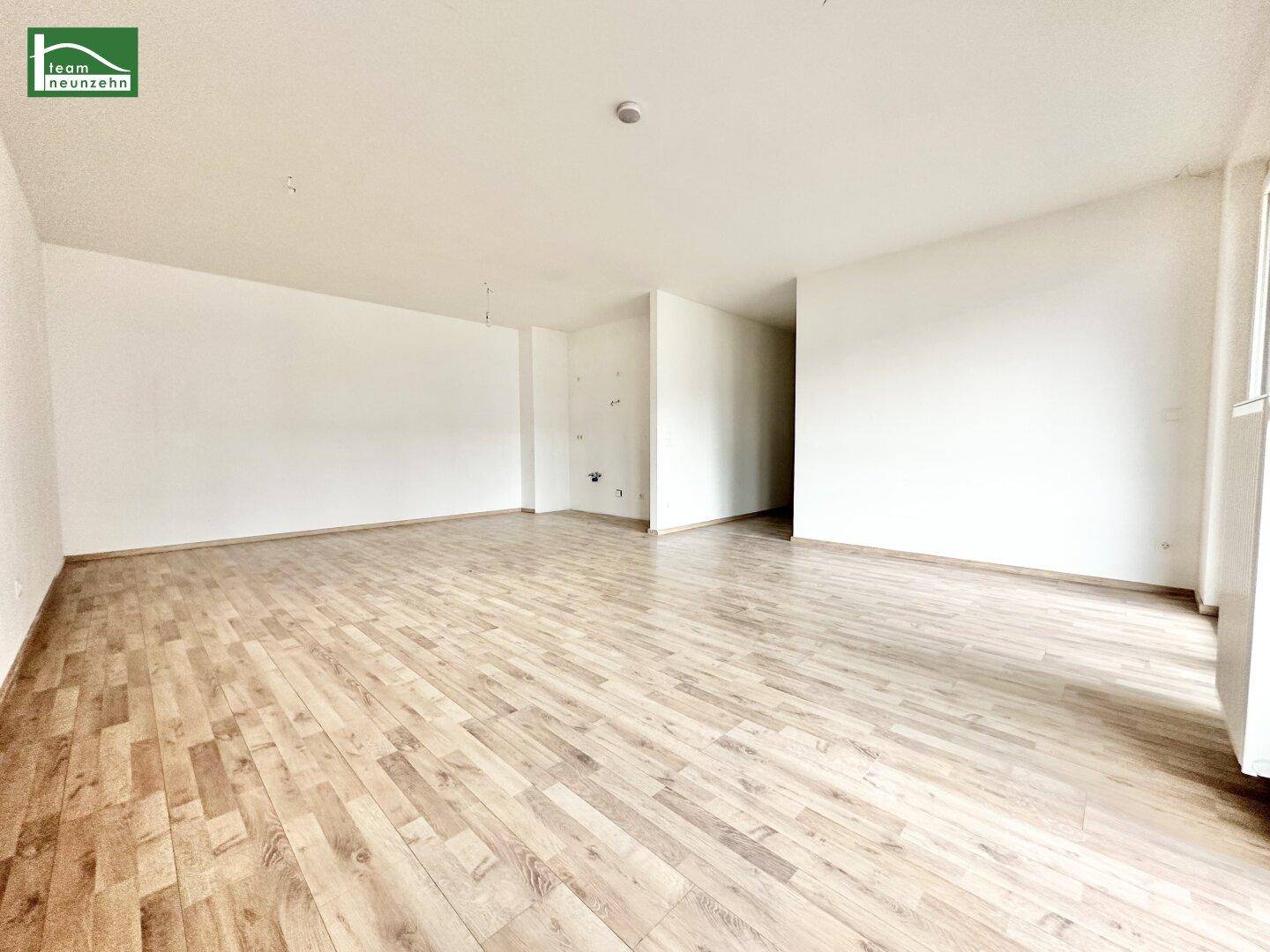 Heller, leerer Raum mit Laminatboden und weißen Wänden, bereit zur individuellen Gestaltung.