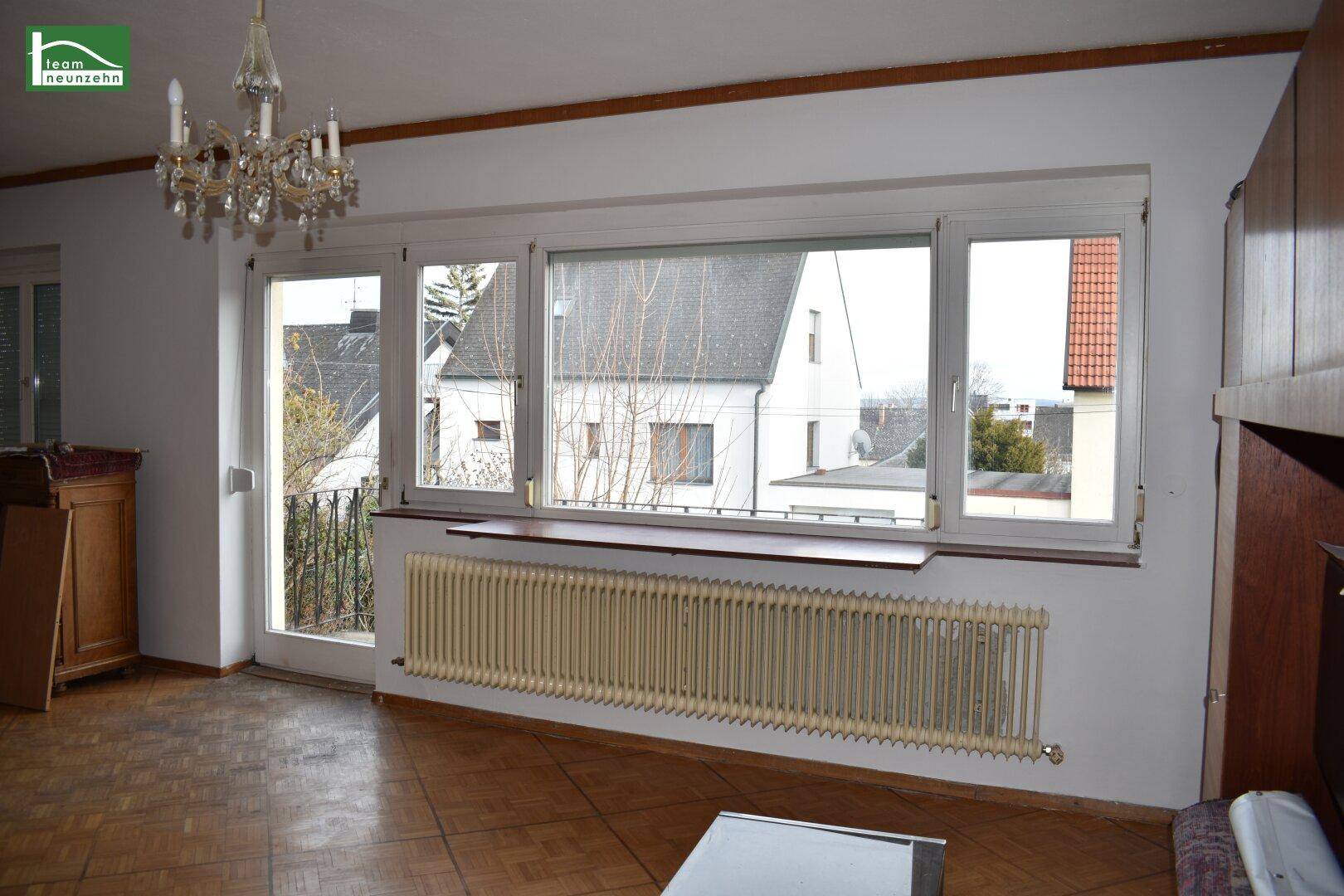 Helles Wohnzimmer mit großzügiger Fensterfront und direktem Zugang zum Balkon.