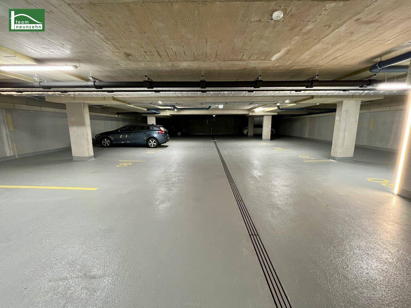Tiefgarage mit markierten Stellplätzen und einem geparkten Fahrzeug.